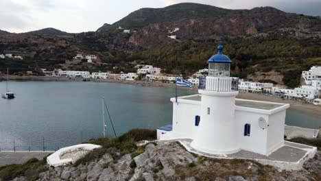 Kythira,-Griechischer-Inselstrand-Und-Weißer-Leuchtturm-Mit-Weißen-Dorfhäusern-Im-Hintergrund