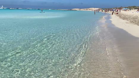Summer-vacation-in-Formentera-island-Ses-Illetes-beach-Ibiza-Spain,-transparent-turquoise-water-on-a-white-sand-beach,-people-on-holiday,-sunny-day,-4K-shot