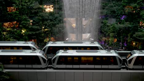 Skytrain's-Passing-Each-Other-Beside-Indoor-Waterfall-At-Jewel-Changi-Airport-In-Singapore