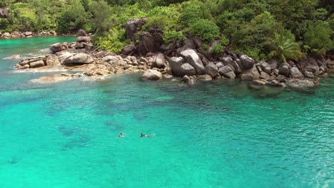 Drohne-Am-Strand-Von-Anse-Major,-2-Frauen-Beim-Schnorcheln,-Granitsteine,-Türkisfarbenes-Wasser,-Mahé,-Seychellen,-60-Fps