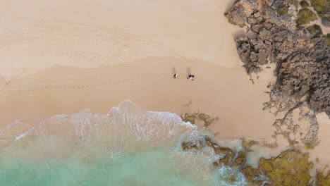 Ein-Paar-Spaziert-Entlang-Des-Cape-to-Cape-Wanderwegs-In-Yallingup,-Westaustralien,-Durch-Einen-Felsigen-Strandabschnitt