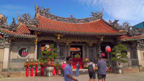 Frontalansicht-Des-Longshan-Tempels-In-Taipeh-Mit-Touristen,-Die-Durch-Den-Rahmen-Gehen