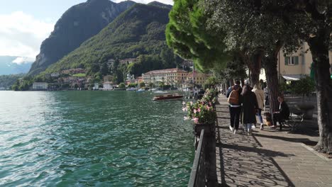 Una-Pareja-Joven-Camina-Por-El-Paseo-Marítimo-De-La-Ciudad-De-Menaggio,-Cerca-Del-Lago-De-Como.