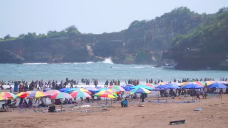 Coloridas-Sombrillas-Y-Gente-En-La-Playa---Baron-Beach,-Indonesia