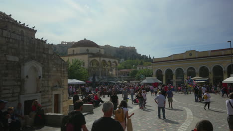 Busy-Athens-square-with-Acropolis-view,-tourists-and-locals