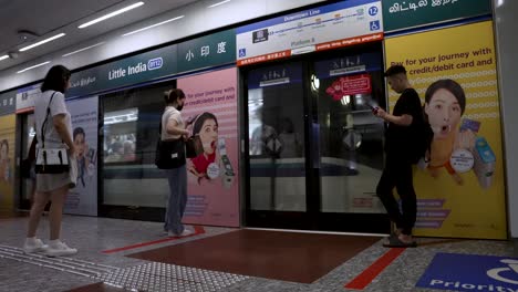 Commuters-Waiting-Beside-Platform-Doors-As-MRT-Train-Approaches-At-Little-India-DT12-Station