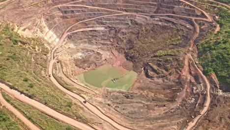 An-aerial-drone-shot-of-dirt-roads-circling-around-the-edges-of-Siana-Gold-and-Silver-Mine-in-Mainit,-Philippines