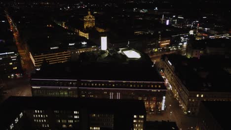 Helsinki-night-flight-over-triangular-department-store,-Stockmans