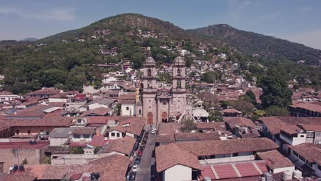 Drone-hovering-between-the-bell-towers-of-the-Parish-of-San-Francisco-de-Asís,-the-church-located-in-the-town-of-Valle-de-Bravo,-State-of-Mexico