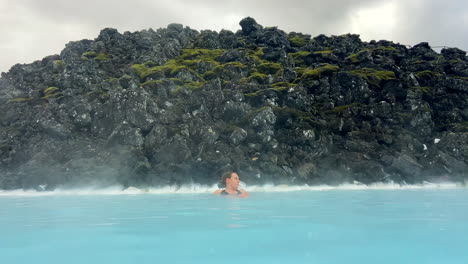 Mujer-Caucásica-Relajándose-En-El-Spa-Termal-Al-Aire-Libre-De-La-Laguna-Azul-En-Islandia