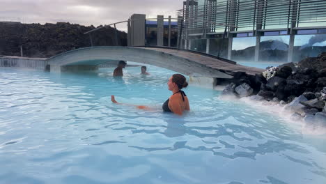 Chica-Rubia-Relajándose-Bañándose-Dentro-De-La-Gran-Laguna-Azul-En-Islandia