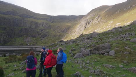 Mountaineers-admiring-the-natural-beauty-and-stunning-landscape-at-Coumshingaun-Lake-in-the-Comeragh-Mountains-Waterford-Ireland-on-a-cold-winter-afternoon