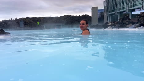 Una-Mujer-Joven-Y-Bonita-Bañándose-Y-Sonriendo-En-La-Laguna-Azul-Islandesa