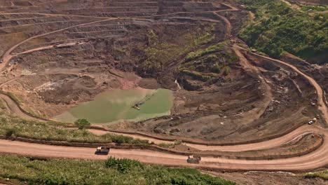 Una-Toma-Aérea-De-Un-Dron-De-Caminos-De-Tierra-Con-Camiones-Circulando-Por-La-Mina-De-Oro-Y-Plata-De-Siana-En-Mainit,-Filipinas