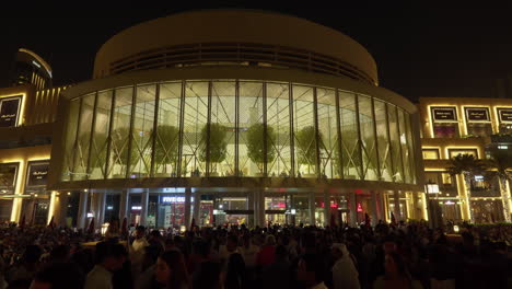 Vista-Nocturna-Del-Bullicioso-Centro-Comercial-Al-Aire-Libre-Con-Una-Multitud-Animada