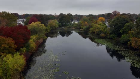 An-aerial-view-over-a-peaceful-pond-on-Long-Island,-New-York,-on-a-cloudy-day-in-autumn