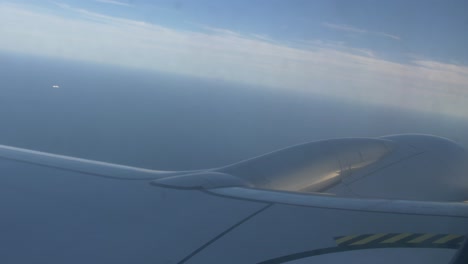 Airplane-flying-over-the-sea,-engine-view