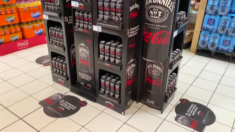 Limited-edition-Jack-Daniels-Coca-Cola-whiskey-can-ready-to-drink-cocktail-at-Carrefour-supermarket-in-Estepona-Spain,-popular-brands,-4K-tilting-up