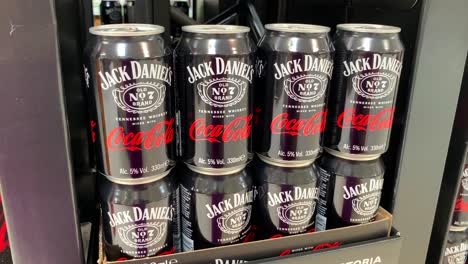 Limited-edition-Jack-Daniels-Coca-Cola-whiskey-can-ready-to-drink-cocktail-at-Carrefour-supermarket-in-Estepona-Spain,-popular-brands-mix,-4K-tilting-up