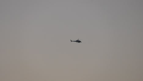 Helicopter-flying-through-sky-at-dawn