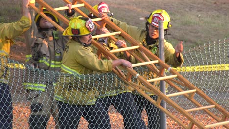 Los-Bomberos-Llevan-Una-Escalera-De-Madera.