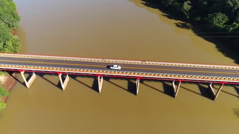 Drone-image-showcasing-a-beautiful-bridge-spanning-over-a-muddy-river