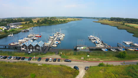 Top-aerial-view-of-drone-flying-to-marina-in-Blotnik,-Pomeranian,-Poland-with-yachts-and-boats
