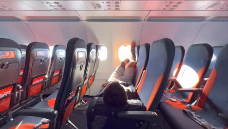 Eine-Person,-Die-Chillt,-Schläft,-Sich-Entspannt-Und-Sich-Mit-Erhobenen-Beinen-Auf-Easyjet-Flugzeugsitzen-Hinlegt,-Easyjet-Flugerlebnis,-Menschen,-Die-In-Den-Urlaub-Fahren,-4K-Aufnahme