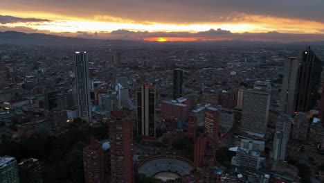 Flying-over-the-skyline-of-Bogota,-colorful-evening-in-Colombia---Aerial-view
