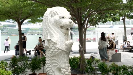 Mini-Merlion-Sculpture-In-Singapore-With-Tourists-Walking-Past-In-Background