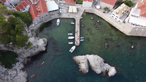 People-swimming-and-kayaking-at-west-harbor-bay-of-Dubrovnik-city,-Aerial