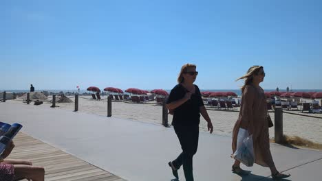 Coronado-Strandpromenade-Mit-Fußgängern,-Sonnenschirmen-Und-Liegestühlen-An-Einem-Sandstrand