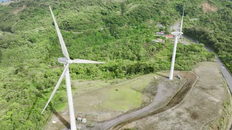 Majestic-aerial-footage-of-elongated-wind-turbines-atop-rolling-hills
