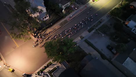 Cyclists-in-night-bike-race-through-streets,-Littleton-Twilight-Criterium