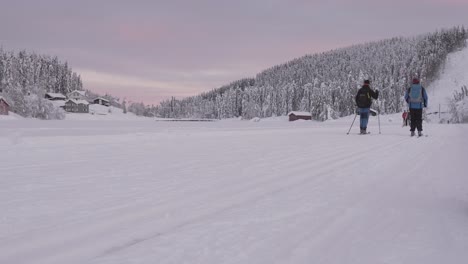 Static-close-up-shot-of-cross-country-skiers-on-frozen-Lake-Mylla-in-Norway