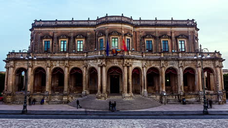 Una-Toma-De-Lapso-De-Tiempo-De-Un-Edificio-Del-Municipio-Palaciego-De-Ducezio-Con-Banderas-En-Italia