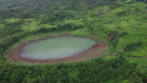 Aerial-view-of-sacred-lake-at-the-Brahmagiri-hill-in-the-Western-Ghats-of-Maharashtra-during-monsoon,-Nashik,-India