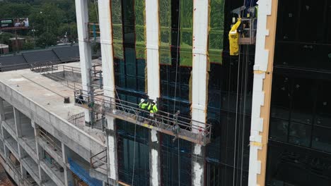 Luftaufnahme,-Die-Einen-Arbeiter-Auf-Der-Baustelle-Zeigt,-Der-Fenster-An-Einem-Wolkenkratzergebäude-In-Atlanta-Installiert