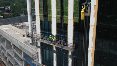 Aerial-view-showing-worker-on-construction-site-installing-windows-on-skyscraper-building-in-Atlanta