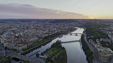 Prague-Czechia-Aerial-v67-flyover-Vltava-river-and-Stvanice-Island-capturing-riverside-cityscape-of-Petrska-Ctvrt,-Holesovice-and-Old-Town-districts-at-sunset---Shot-with-Mavic-3-Cine---November-2022