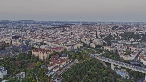 Prague-Czechia-Aerial-v119-flyover-Park-Folimanka-capturing-historical-church-and-chapel,-busy-traffics-on-Nuselsky-Most-streets-and-New-town-cityscape-at-dusk---Shot-with-Mavic-3-Cine---November-2022