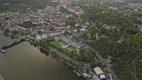 Prague-Czechia-Aerial-v104-birds-eye-view,-drone-flyover-Vltava-river-capturing-historical-landmark-of-Straka-Academy,-tilt-up-capturing-panoramic-cityscape---Shot-with-Mavic-3-Cine---November-2022