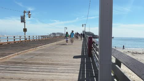 Día-Soleado-Y-Gente-Disfrutando-Del-Paseo-Por-El-Muelle-De-Madera-De-Santa-Bárbara-En-La-Costa-Californiana