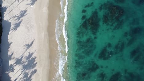 Bird-eye-aerial-of-Palmilla-Beach-in-Cabo-San-Lucas,-slice-of-paradise-on-the-southern-tip-of-the-Baja-California-Peninsula,-with-its-pristine-sandy-shores-and-crystal-clear-waters