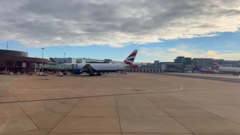 Airplane-driving-around-an-international-airport-in-England,-flying-on-holiday-vacation,-4K-shot