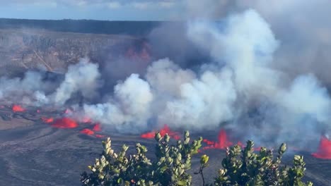 Cinematic-long-lens-panning-shot-with-volcanic-plants-in-the-foreground-of-lava-and-gasses-pouring-from-Kilauea-Crater-on-the-first-day-of-eruption-in-September-2023-in-Hawai'i