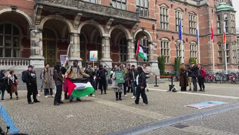 Pro-Palestina-Demonstration-Waving-Palestinian-Flag,-Student-Protesting-In-front-of-Rijksuniversiteit-Groningen