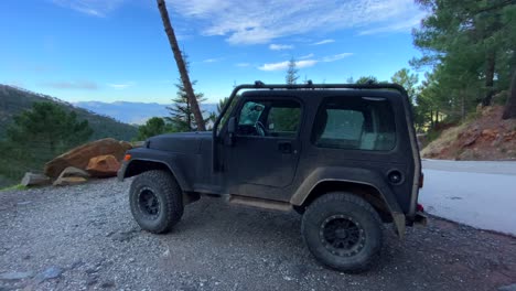 Jeep-Negro-4x4-Con-Hermosa-Naturaleza-Y-Vistas-Al-Bosque-Alrededor-De-Una-Montaña,-Divertidas-Aventuras-En-Vehículos-Todo-Terreno-En-Un-Día-Soleado-En-Marbella-Málaga-España,-Toma-De-4k