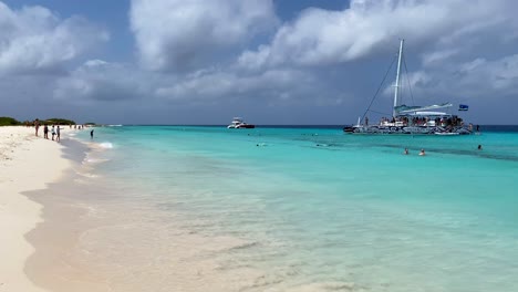 Aguas-Cristalinas-De-Color-Turquesa-Transparente-En-La-Playa-Tropical-De-Arena-Blanca-De-Klein-Curaçao,-Barco-De-Alquiler-Bluefinn,-Destino-De-Vacaciones-De-Ensueño-En-Little-Curaçao,-La-Isla-Caribeña-Holandesa,-Toma-Estática-De-4k