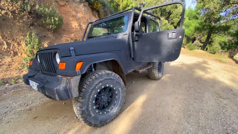 Cool-Jeep-4x4-car-with-green-forest-around-on-a-mountain-road,-fun-ATV-nature-adventures-in-Marbella-Malaga-Spain,-4K-shot